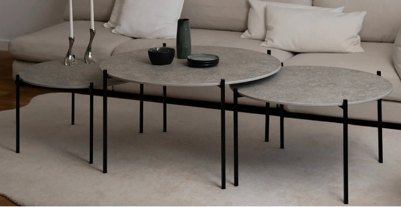 Modern living room with a beige sectional sofa and round coffee table.